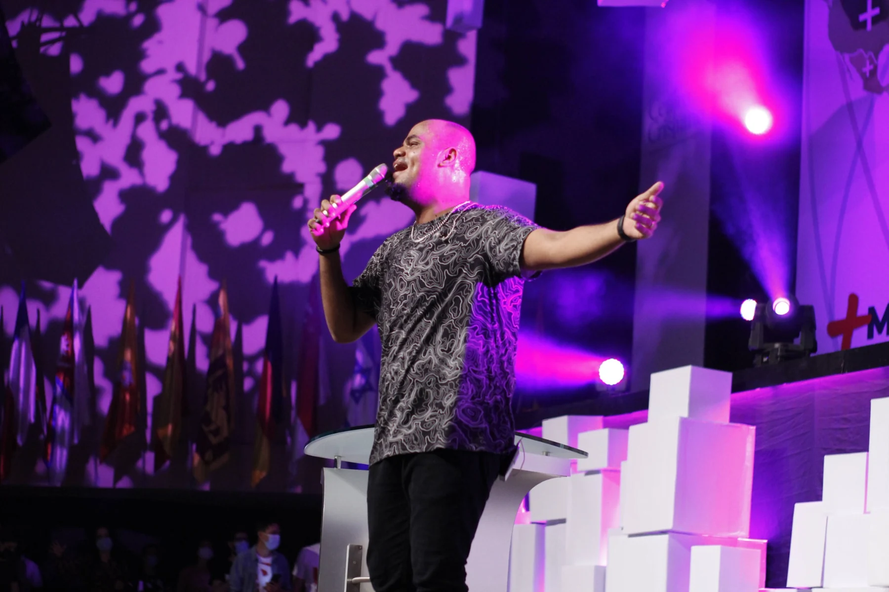 Wiliam Oliveira cantando en un escenario con iluminación violeta
